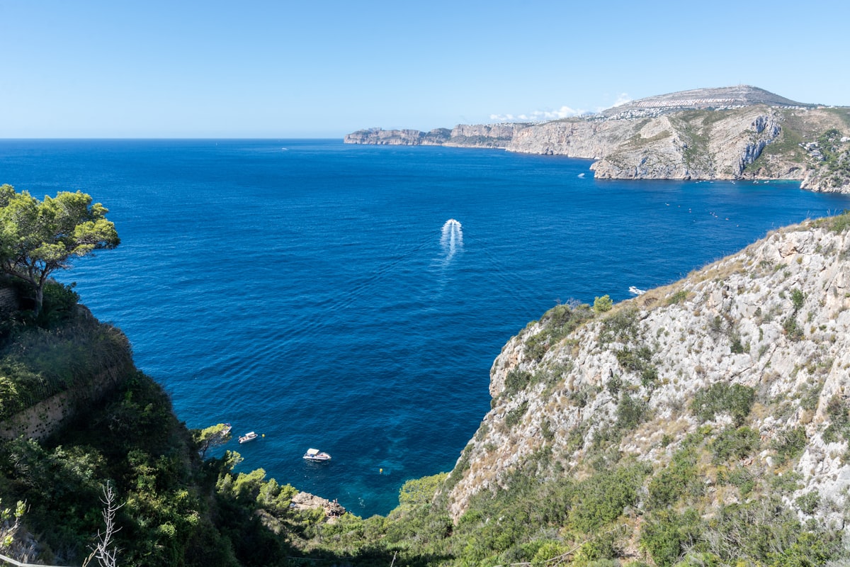 Uitzicht op de kustlijn van Javea met boten en bergen aan de Costa Blanca