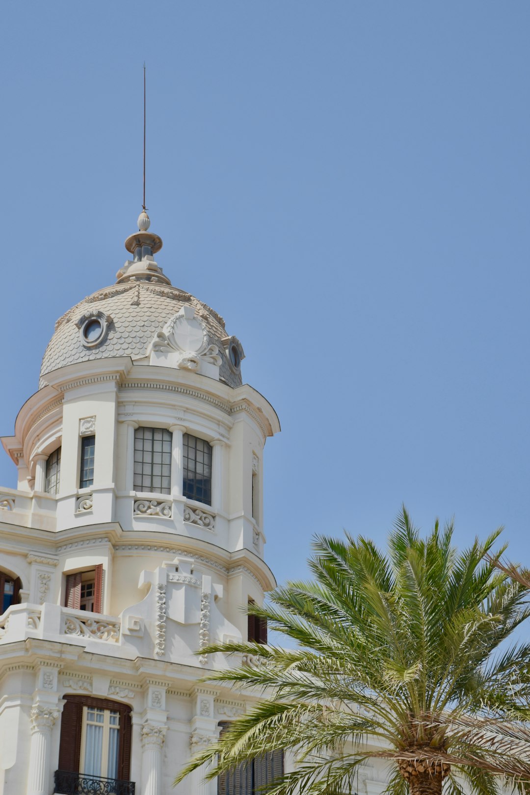 Witte barokkerk met palmboom in Dolores, Vega Baja del Segura, Spanje