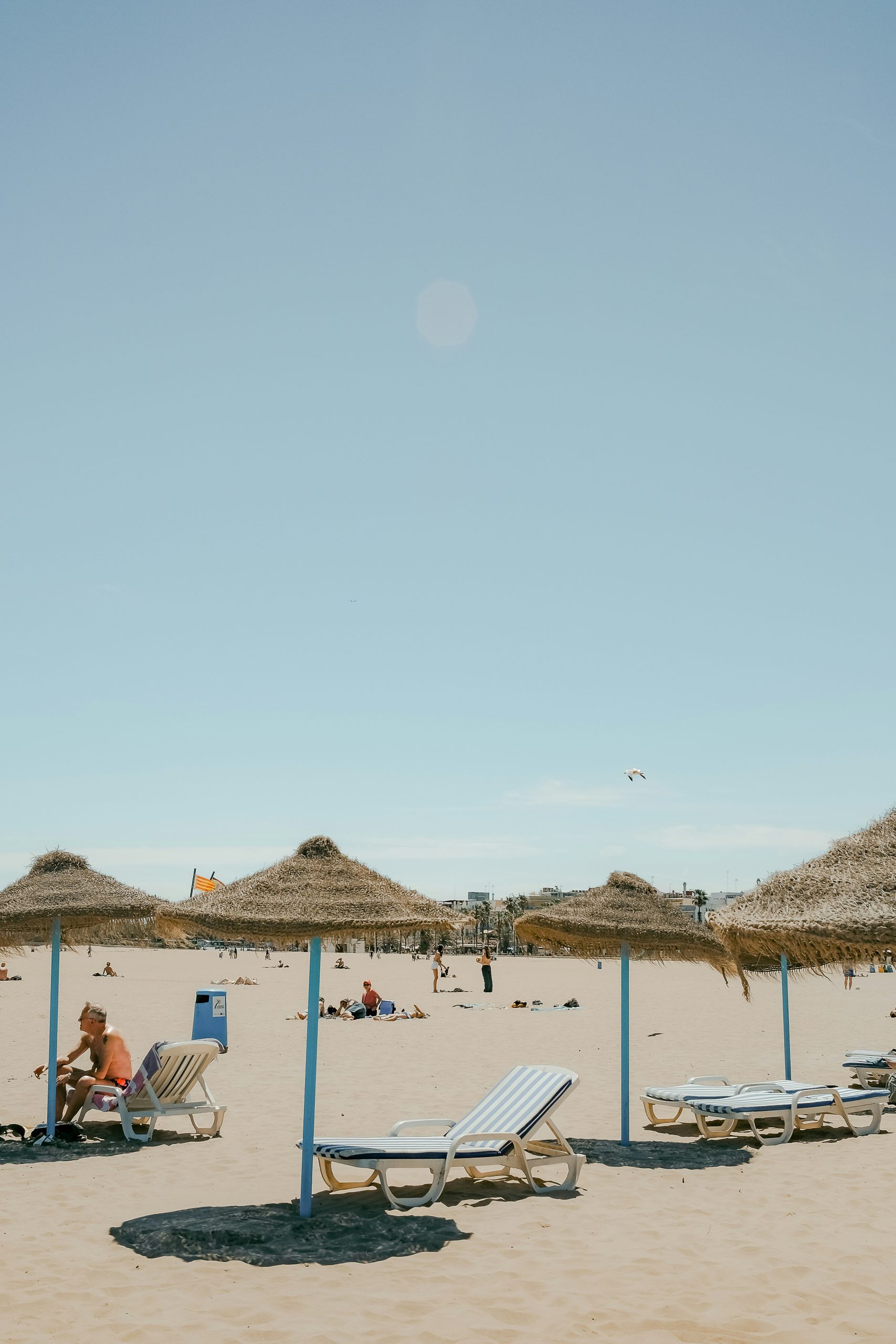 Zandstrand met ligbedden en stro parasols aan de kust van Spanje