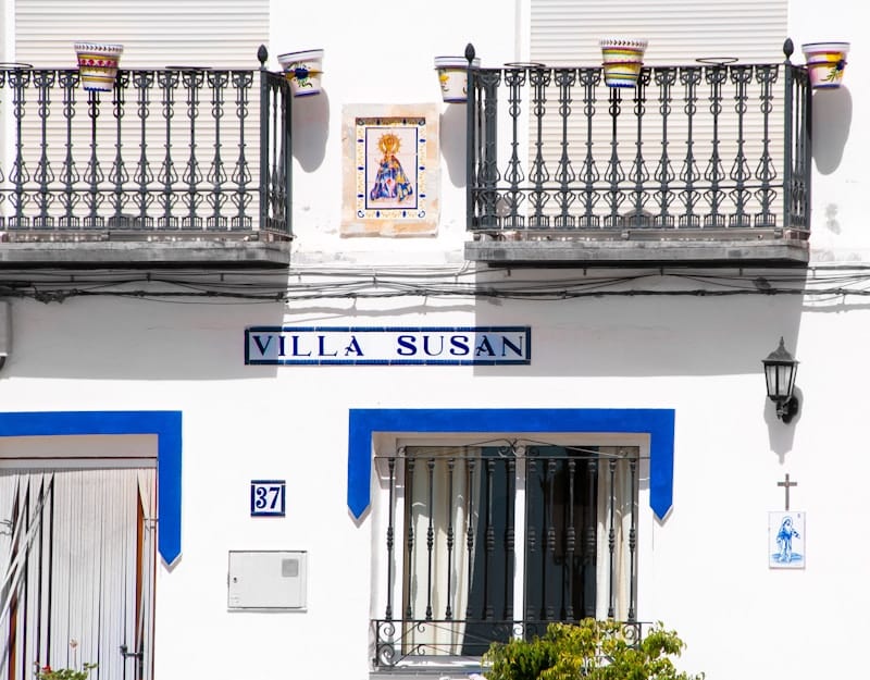 Spaanse witte villa met blauwe deur en balkon, voorbeeld van een huurwoning in Spanje