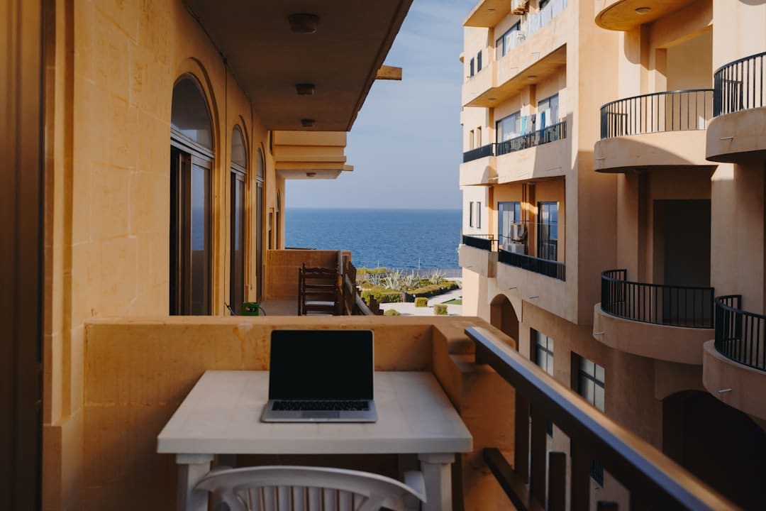 Laptop op een terras in Spanje terwijl iemand op afstand werkt voor een Nederlandse werkgever